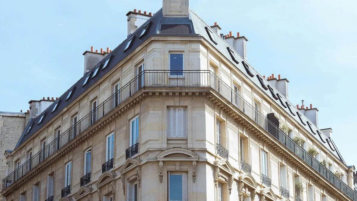 Façade en pierre claire, balcons en ferronnerie et toiture en zinc