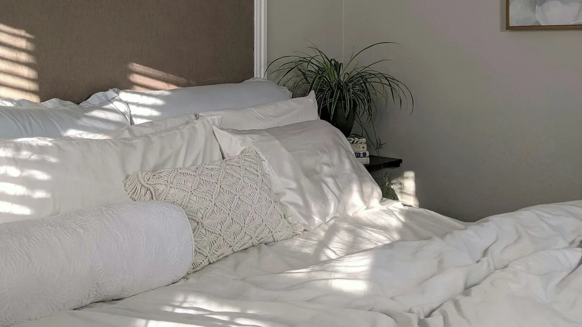 Chambre lumineuse avec un lit et du linge blanc